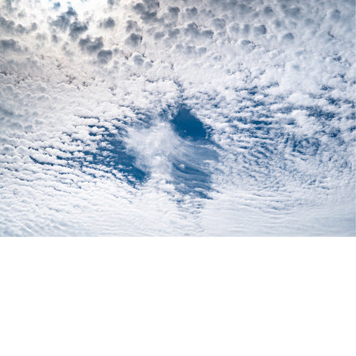Wolken, een fallstreak hole (ook wel hole-punch cloud): een “gat” in een veld altocumulus/stratocumulus.