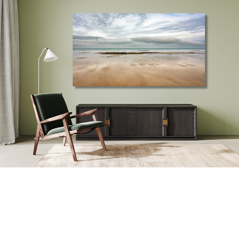 Uitgestrekt zandstrand onder een indrukwekkende wolkenlucht