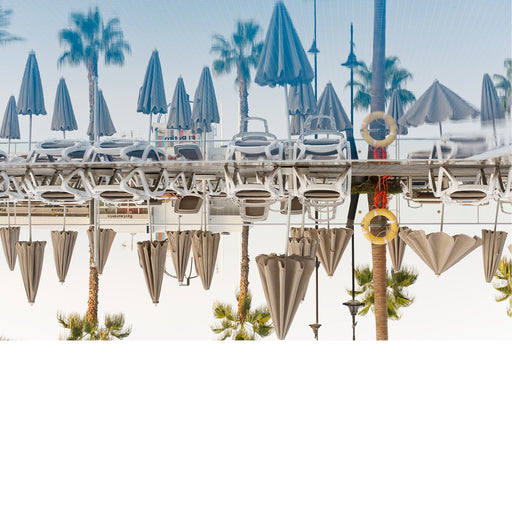 Weerkaatsing van palmbomen en ligstoelen in een zwembad. Tropisch sfeerbeeld. 