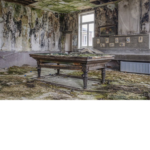 Biljarttafel in een totaal vervallen kamer waar de schimmel en het mos de muren sieren