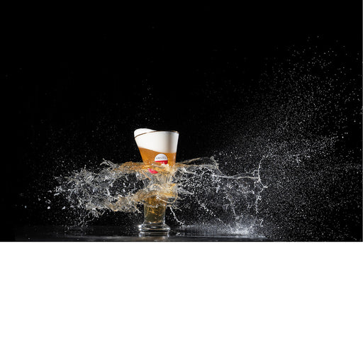 Highspeedfoto, waarbij een bierglas wordt doorboord door een kogel