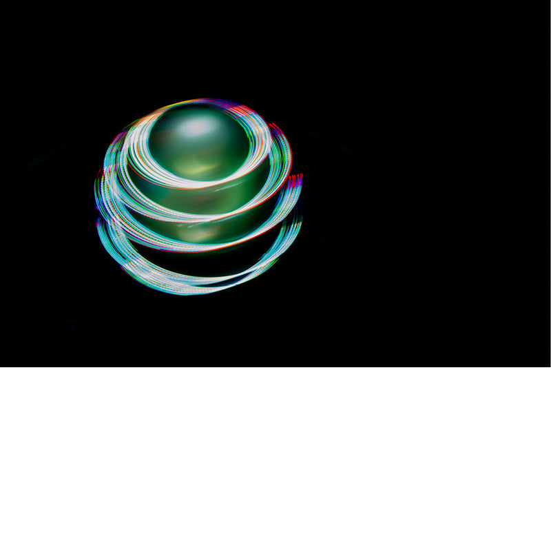 Ronddraaiende lichtsporen in regenboogkleuren vormen een gloeiende bol tegen een diepzwarte achtergrond.