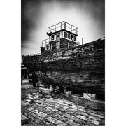 Een oud verlaten schip rust na vele avonturen op zee uit aan wal. Het verweerde hout, het roestige ijzer, ze vertellen een hele geschiedenis.