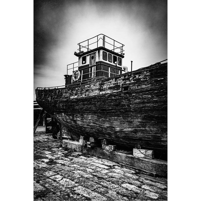 Een oud verlaten schip rust na vele avonturen op zee uit aan wal. Het verweerde hout, het roestige ijzer, ze vertellen een hele geschiedenis.