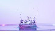 macro-opname van een waterdruppel op het moment van impact in roze tinten