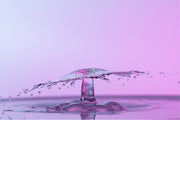 macro-opname van 2 druppels water die op elkaar botsen in roze tinten