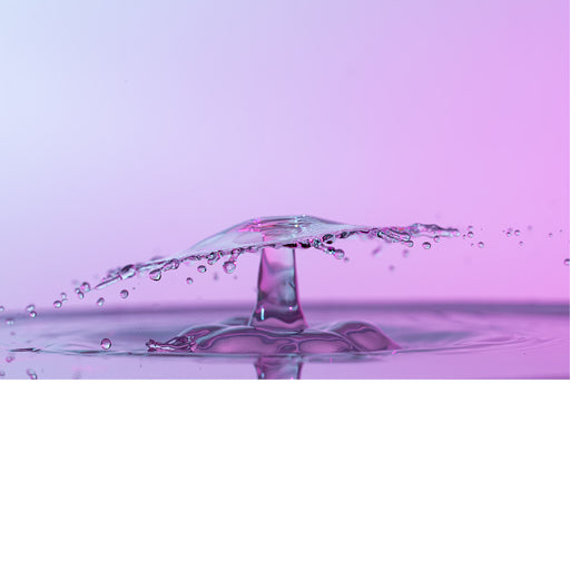 macro-opname van 2 druppels water die op elkaar botsen in roze tinten