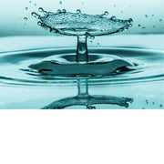 macro-opname van 2 druppels water die op elkaar botsen met reflectie in groene tinten
