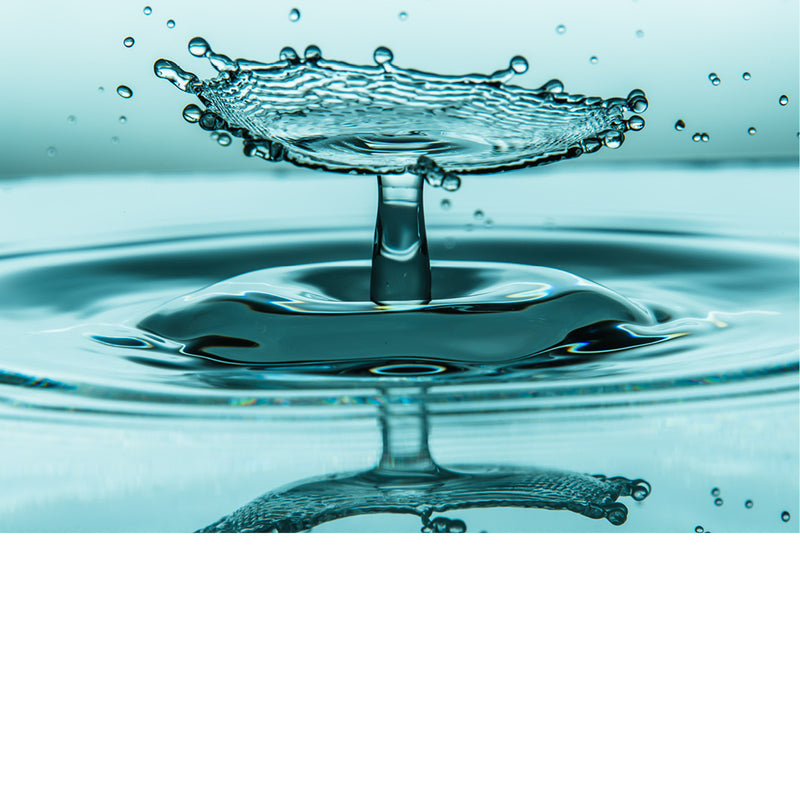 macro-opname van 2 druppels water die op elkaar botsen met reflectie in groene tinten