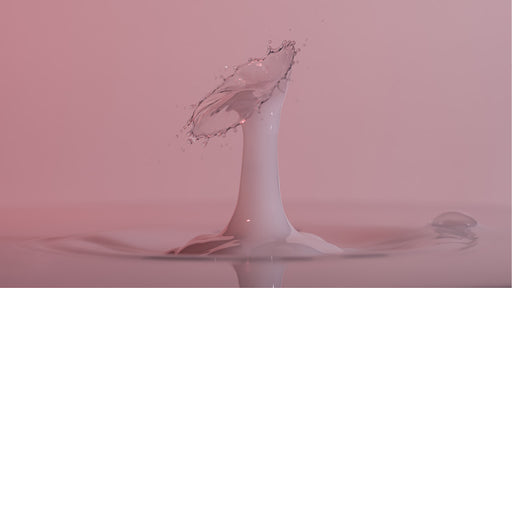 macro-opname van 2 druppels water die op elkaar botsen in melk in roze tinten