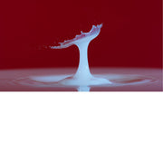 macro-opname van 2 druppels water die op elkaar botsen in melk in rode tinten