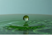 macro-opname van een vallende druppel in blauw met groene tinten