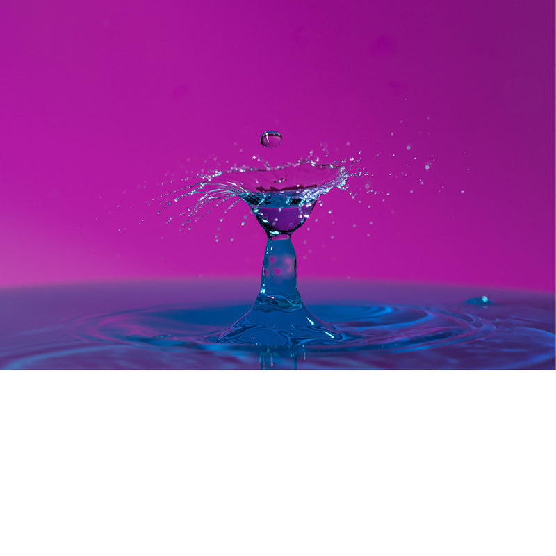 macro-opname van 2 druppels water die op elkaar botsen in roze met blauwe tinten
