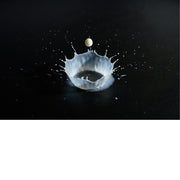 macro-opname van druppel melk vallend op zwarte ondergrond