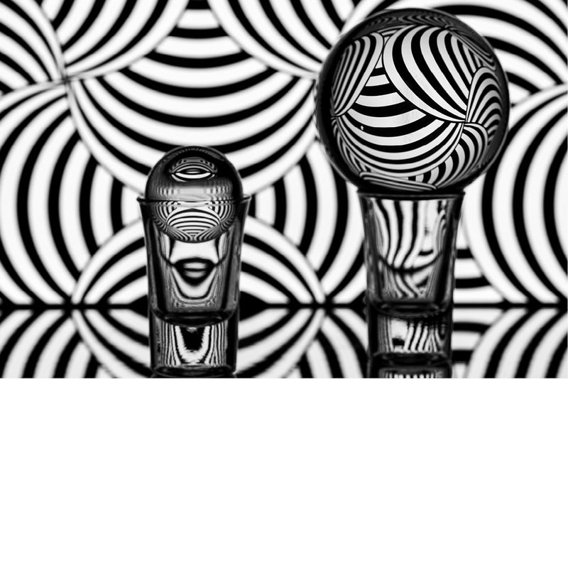 macro-opname van 2 lensballen op een spiegel met zwart-witte achtergrond