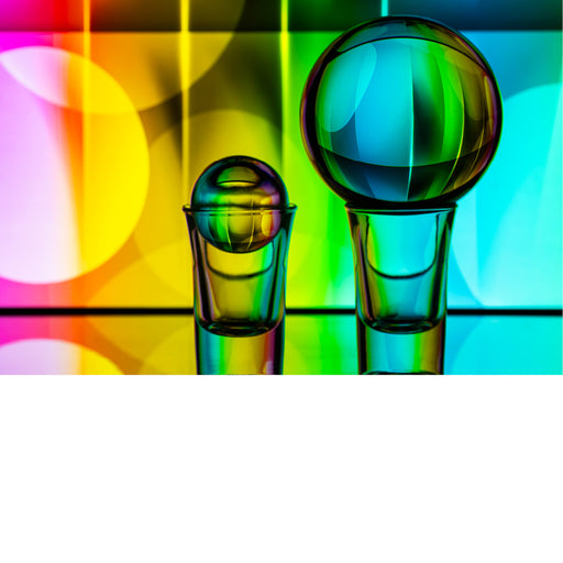 macro-opname van 2 lensballen op een spiegel met gekleurde achtergrond