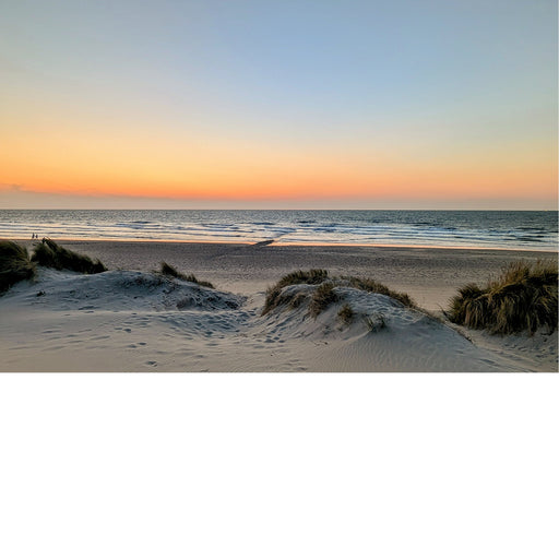 Een warme zonsondergang aan de Belgische kust, vanop de dijk in Westende.
