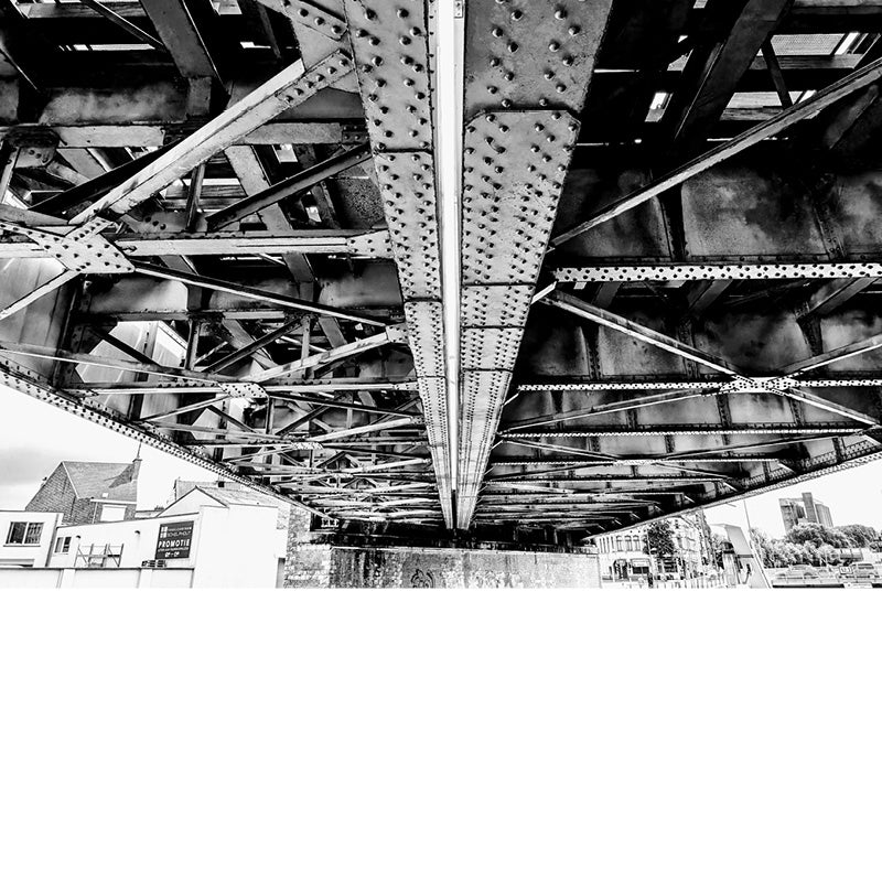 Een aparte blik op een brug, waar de constructie met klinknagels zichtbaar is langs de onderzijde.