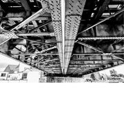 Een aparte blik op een brug, waar de constructie met klinknagels zichtbaar is langs de onderzijde.