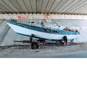 Onder een brug staat een versleten bootje fout geparkeerd.