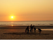 Kinderen spelen nog een laatste spel op het strand voor de avond valt.