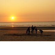 Kinderen spelen nog een laatste spel op het strand voor de avond valt.