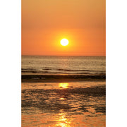 Een warme zonsondergang met reflecties in het zeewater.