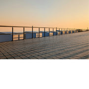 De opkomende zon werpt schaduwkruisen op de strandcabines.