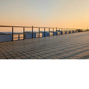 De opkomende zon werpt schaduwkruisen op de strandcabines.