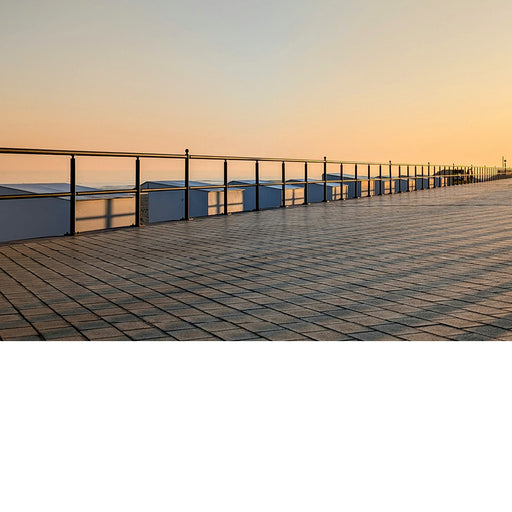 De opkomende zon werpt schaduwkruisen op de strandcabines.