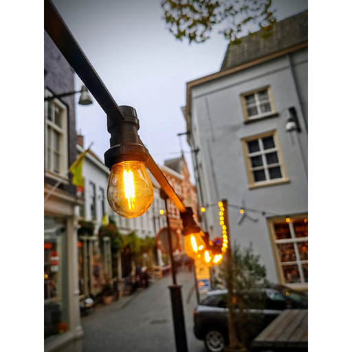 Sfeerbeeld van een straat in Breda, met een warme gloed van lampjes.