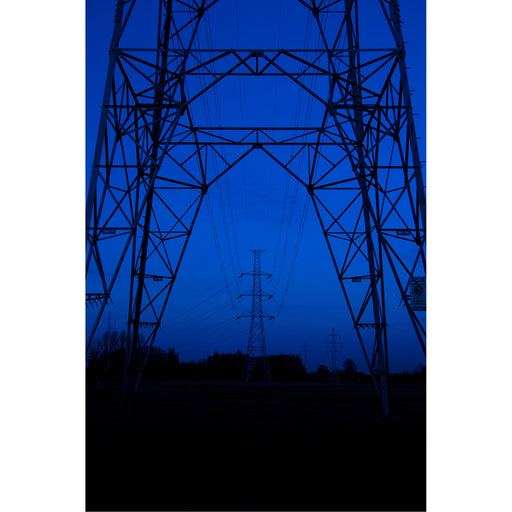 Hoogspanningspalen op lijn tijdens het blauwe uurtje.