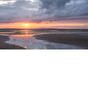 Deze zonsondergang is fantastisch. Een warme gloed met daarboven intense wolken en onderaan reflecties op het strand.