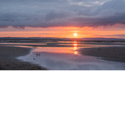 Deze zonsondergang is fantastisch. Een warme gloed met daarboven intense wolken en onderaan reflecties op het strand.