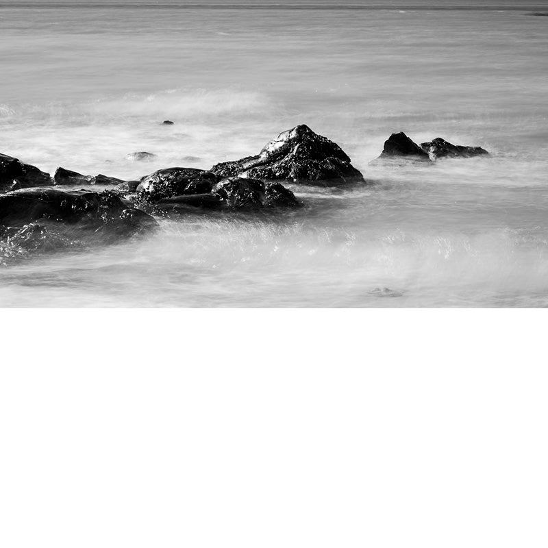 Door de lange sluitertijd krijgt het water rond de rotsen een effect van wolken.