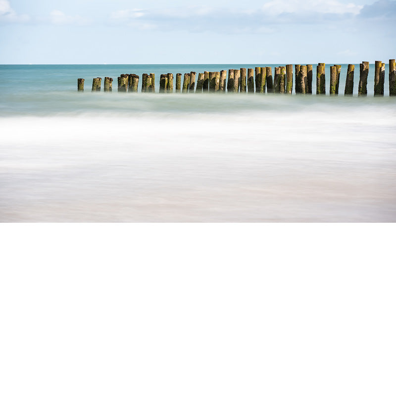 De paalhoofden op het strand langs de Opaalkust lijken op te lossen in de zee, met dank aan de lange sluitertijd.