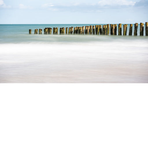 De paalhoofden op het strand langs de Opaalkust lijken op te lossen in de zee, met dank aan de lange sluitertijd.