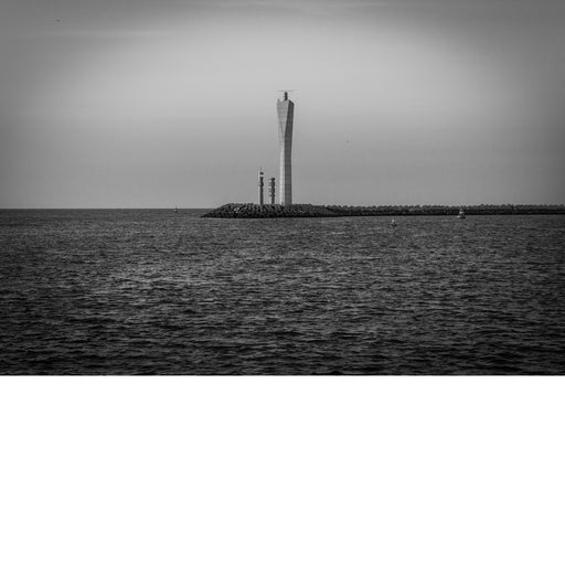 Slanke, gedraaide radartoren op de golfbreker van Oostende, die boven een rimpelende zee uitsteekt onder een egale grijze lucht.