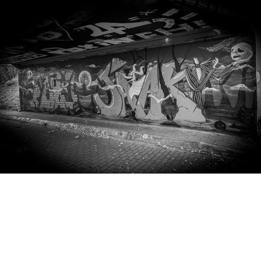 Grote graffitimuurschildering met griezelige figuren, een kerkhof en een volle maan in een tunnel in Hasselt.
