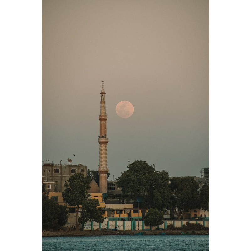 De volle maan schijnt over een moskee in Egypte