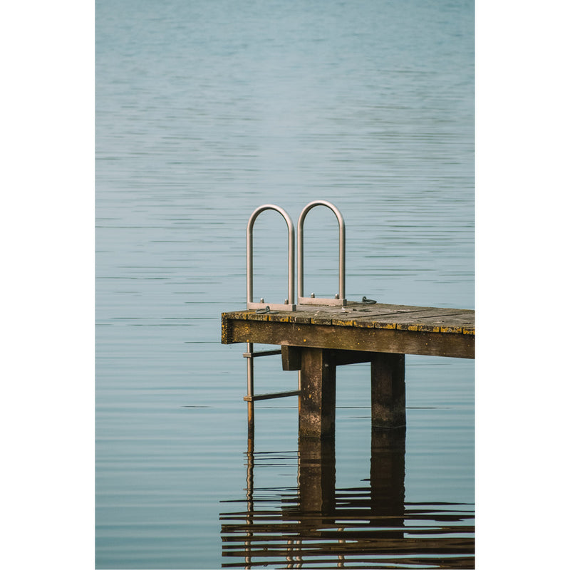 Een laddertje gaat van een steiger de zee in