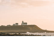 De zon zakt weg en werpt een warm licht op een vuurtoren