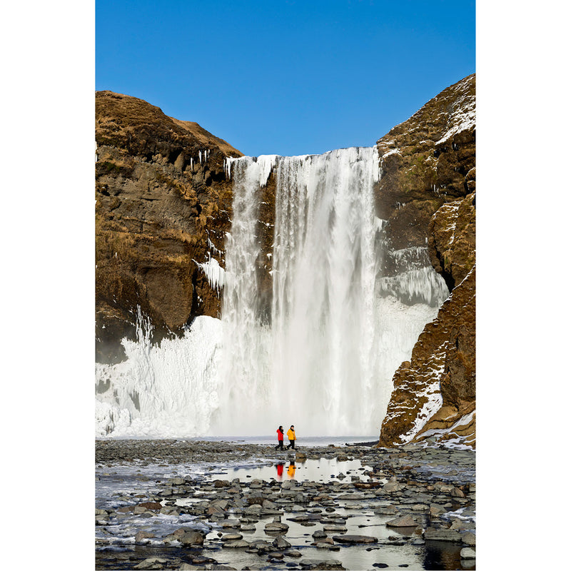 IJsland, Skógafoss waterval, met 2 mensen die weerspiegelen in het water