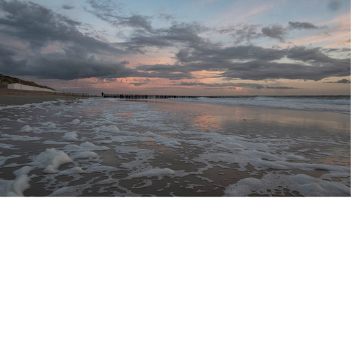 Eenzame wandelaar op het velaten strand in Westkapelle, Zonsondergang 