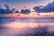 Door het spel van zon en wolken lijkt dit strand wel uit een sprookje te komen.