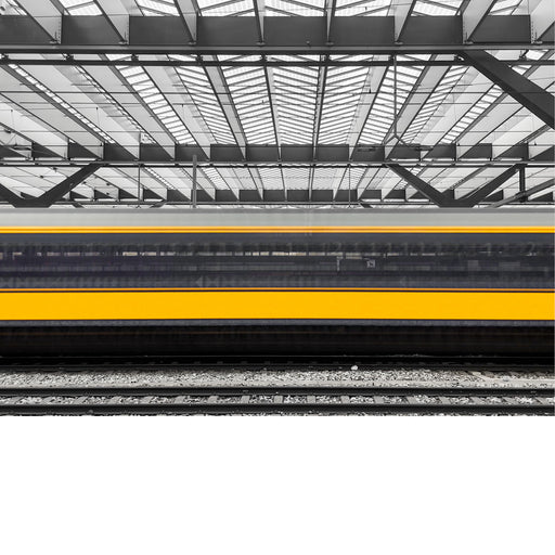 Een trein rijdt door een station, met een focus op het dak van het station en de sporen.