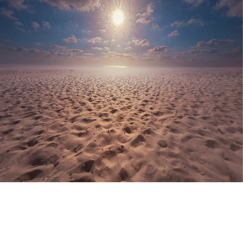 Een uitgestrekte zandvlakte onder een heldere hemel.