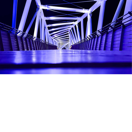 De HaShmurot-brug in Netanya, Israël. Het is een voetgangers- en fietsbrug die 's nachts wordt verlicht met blauwe led-verlichting.