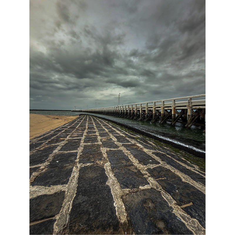Naast de houten pier loopt ook een gofbreker tot in de zee.