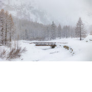 Brugje over besneeuwde rivier in de alpen